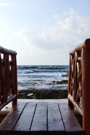 The wooden foot bridge for an exit to a beach against the sea horizonの写真素材