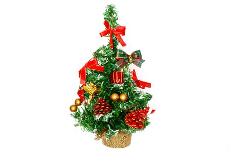 The small decorative fir-tree for Christmas and new year, is decorated with toys and the gifts, isolated on a white backgroundの写真素材