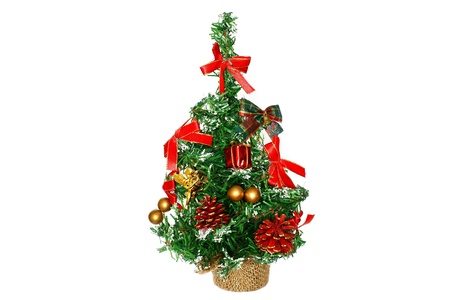 The small decorative fir-tree for Christmas and new year, is decorated with toys and the gifts, isolated on a white backgroundの写真素材