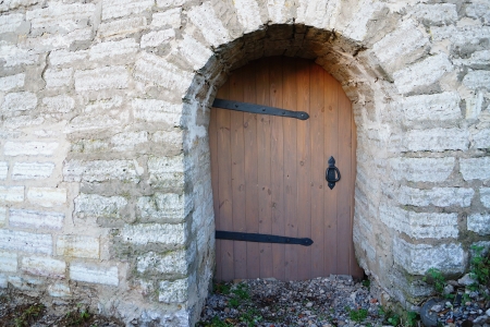 Architecture of an old wooden door in a stone wall closeupの写真素材