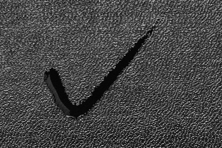 Wet spot in the form of a tick closeup on black leather fabric for an abstract backgroundの写真素材