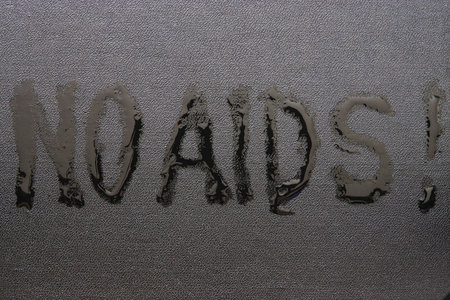 The abstract inscription "NO AIDS" liquid on black rough skinの写真素材