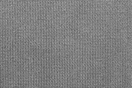 background of abstract texture of woolen or knitted fabric weaved from a gray yarnの写真素材