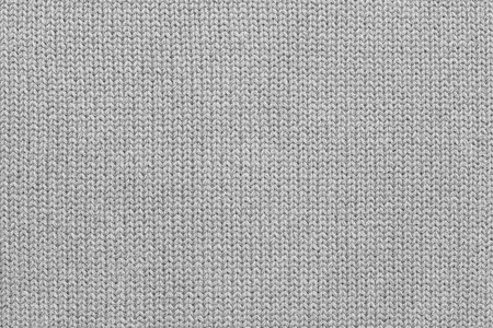 background of abstract texture of woolen or knitted fabric weaved from a light gray yarnの写真素材