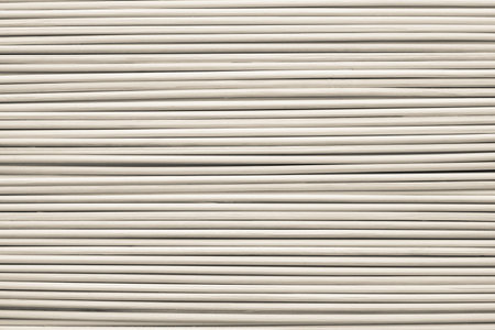 the abstract textured background from wooden cylindrical sticks of beige color