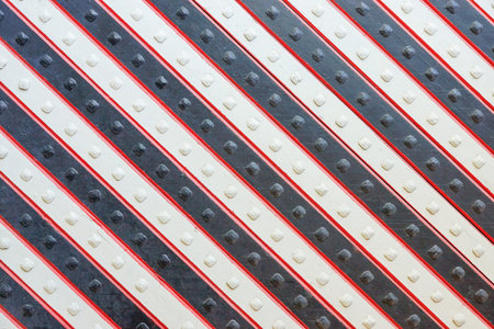 fragment of the ancient riveted panel from the painted wooden boards with a slanting striped patternの写真素材