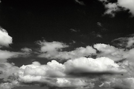 black sky and abstract white cumulus clouds in the lower partの写真素材