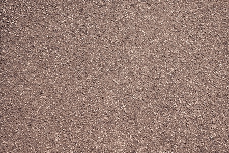 rough granular texture of an old asphalt surface for abstract brown backgrounds with impregnationsの写真素材