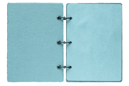 open notebook on a white background with a cover from fabric and with paper pages of blue colorの写真素材