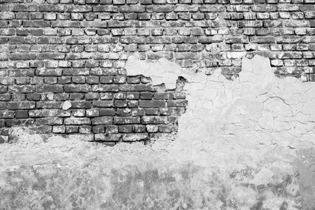 ancient brick wall with the partial destroyed old plaster in monochrome tonesの写真素材