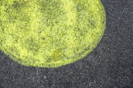 the abstract big round spot of lemon color is represented on black asphaltの写真素材