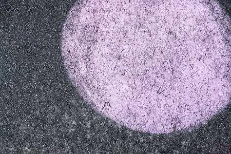 the abstract big round spot of lilac color is represented on black asphaltの写真素材