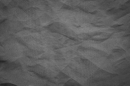 the abstract textured background from crumpled mesh with small cells synthetic fabric of black colorの写真素材