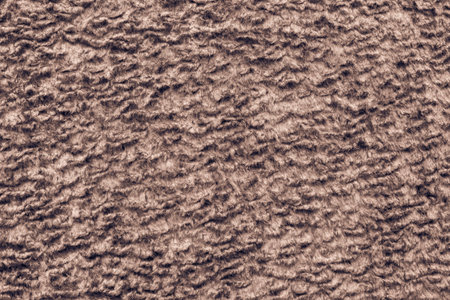 abstract texture of brown color of short-haired fur fabric with wavy curls for empty backgrounds