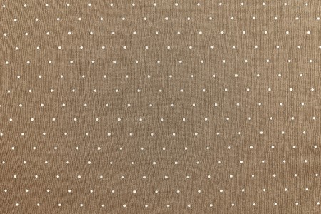 the abstract textured background of sepia color fabric and round light specks are located in ranks on a surface on all areaの写真素材