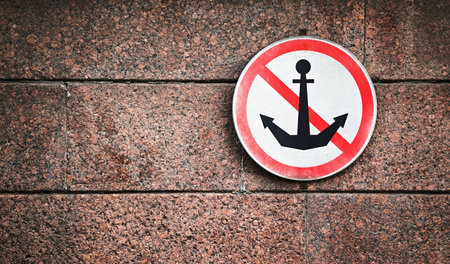 the sign about a ban of the parking of water transport is fixed on a stone wall of the river...