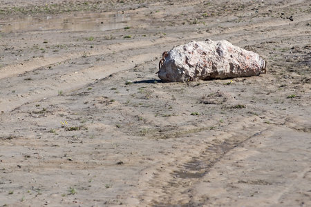 the isolated big piece of old concrete is located on old sandy soil of a building siteの写真素材