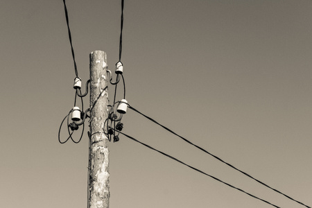 industrial a retro scenery from an old wooden column with electric wires and a cable on ceramic insulators of monochrome beige colorの写真素材