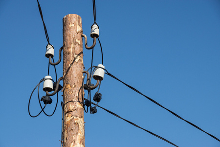 industrial a retro scenery from an old wooden column with electric wires and a cable on ceramic insulators closeupの写真素材