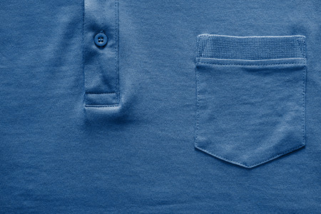closeup part of a shirt from cotton fabric of dark blue color with a big pocket and a fastener with the buttonの写真素材