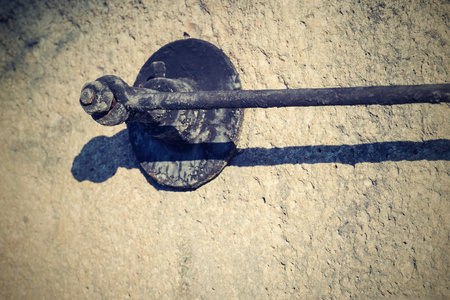 abstract threaded fixing connection from the charred iron on part of an old stone millstoneの写真素材