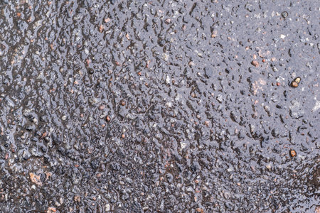 brilliant damp or wet surface of a grained asphalt covering for the abstract textured backgrounds...