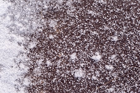 abstract texture of snow and snowflakes on the frozen asphalt with ice for a natural background and for wallpaperの写真素材