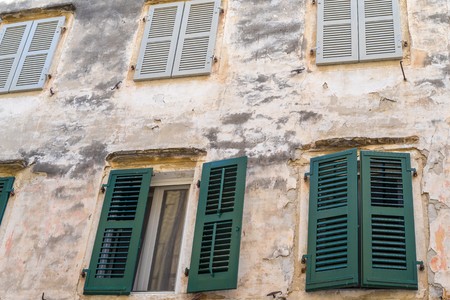 part of a facade of the ancient european house with windows and a sun blind for an architectural background or for wallpaperの写真素材