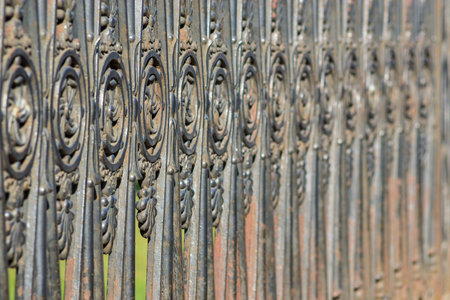 ancient fencing from old iron with an abstract pattern for architectural backgrounds with a blank...
