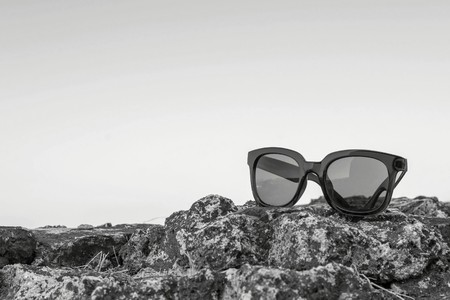modern sunglasses from plastic of monochrome color are separately on a stone closeup against the emptyの写真素材