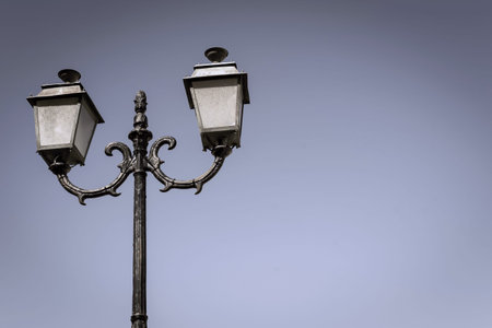 the isolated ancient lamp on an iron column against the sky
