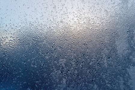 abstract texture various patterns of the frozen water on a glass surface against a sunlight for a fantastic background or for wallpaperの写真素材