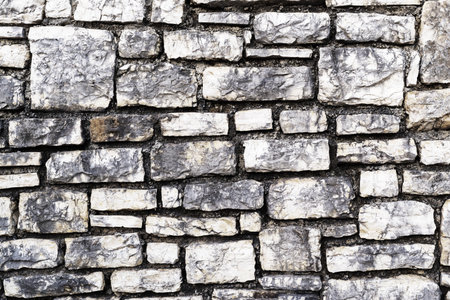 the rough grooved textured surface of a stone wall for a vintage background or for wallpaper