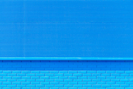 the textured background from corrugated iron and a brick of blue color and a blank space for the...