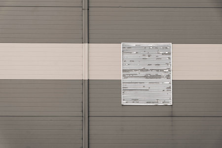 wall from corrugated iron of beige color with one window with blinds and a blank space