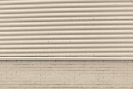 the textured background from corrugated iron and a brick of beige color and a blank space for the textの写真素材