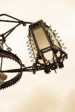big ancient iron streetlight or lamp in retro style closeup and isolated against the skyの写真素材