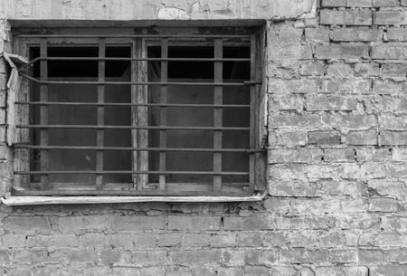 old window closeup with a rusty lattice on an ancient brick wall of monochrome tone and a blank spaceの写真素材