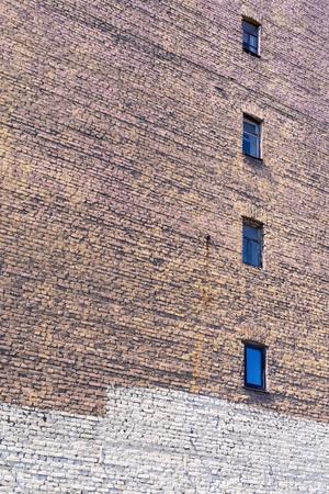 old big brick wall with windows for textured vintage backgroundの写真素材