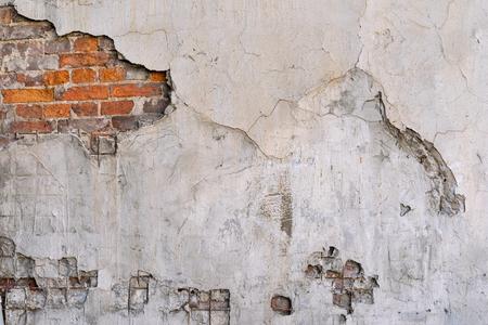 the old textured brick wall with the destroyed plaster for an abstract background or for wallpaperの写真素材