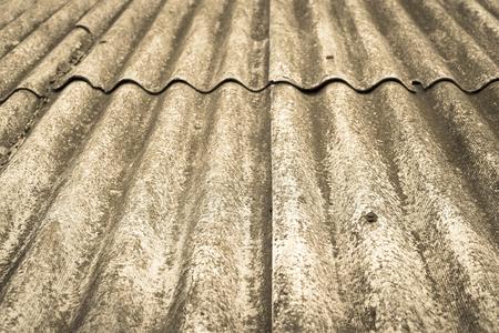 the abstract textured background a closeup of old wavy asbestos-cement slate of tone sepiaの写真素材