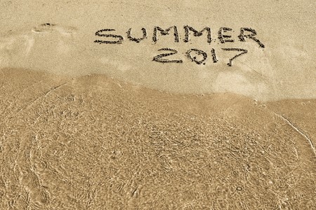 summer of 2017 an inscription closeup on wet sand of the sea coastの写真素材