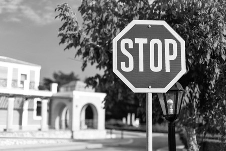 big road sign stop closeup on the street of the settlement or the city of monochrome toneの写真素材
