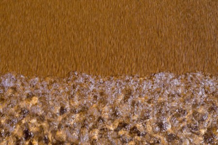 abstract texture of a surf closeup on the sandy coastの写真素材