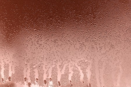 abstract background and brilliant texture of copper color of wet glass with drops of water and with frost or with hoarfrostの写真素材