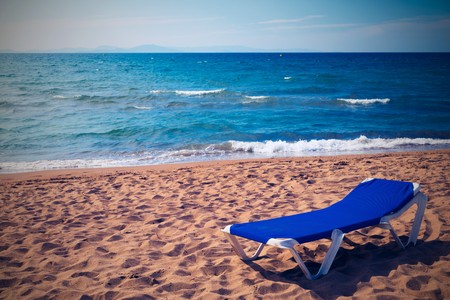 one plank bed for suntan is located a closeup on the sandy seashore in retro styleの写真素材