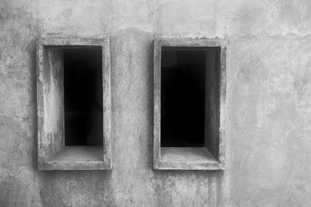 two empty window openings on an old stone wall and a blank space for the text of monochrome toneの写真素材