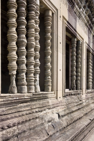 Cambodia a fragment of a wall ancient the building or the temple with historical windows and columns