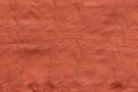 the textured background of old fabric or textile material of red color
