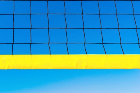 black grid with the yellow edging for playing volleyball closeup against the background of the blue skyの写真素材